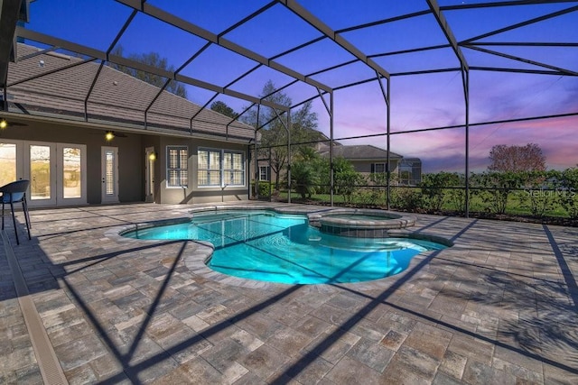 pool at dusk with glass enclosure, french doors, a patio area, and a pool with connected hot tub