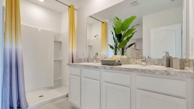 bathroom with a shower with shower curtain, a sink, and visible vents