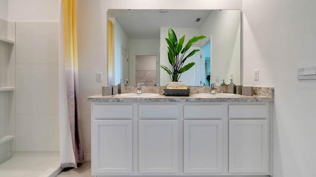 full bath with walk in shower, visible vents, a sink, and double vanity