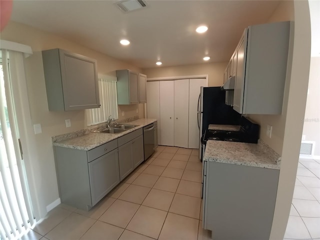 kitchen with visible vents, gray cabinets, light countertops, stainless steel dishwasher, and a sink