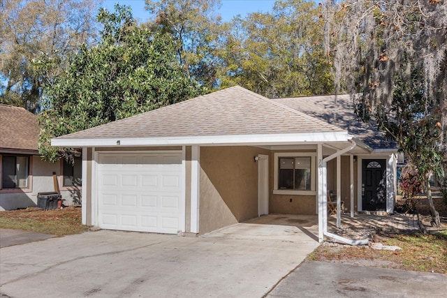 view of front of home with an attached garage, roof with shingles, concrete driveway, and stucco siding