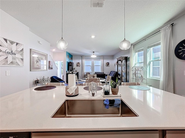 kitchen featuring a healthy amount of sunlight, visible vents, open floor plan, and decorative light fixtures