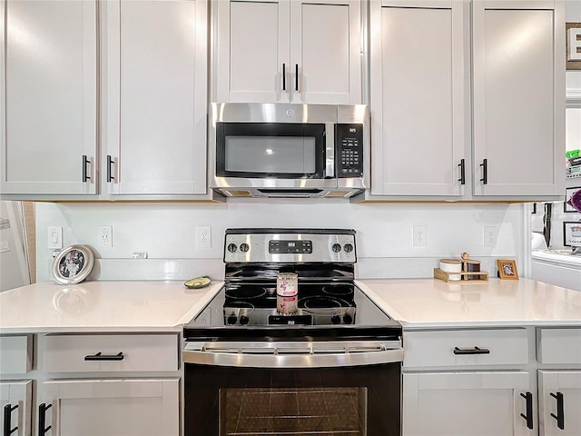 kitchen with washer / dryer, appliances with stainless steel finishes, and light countertops