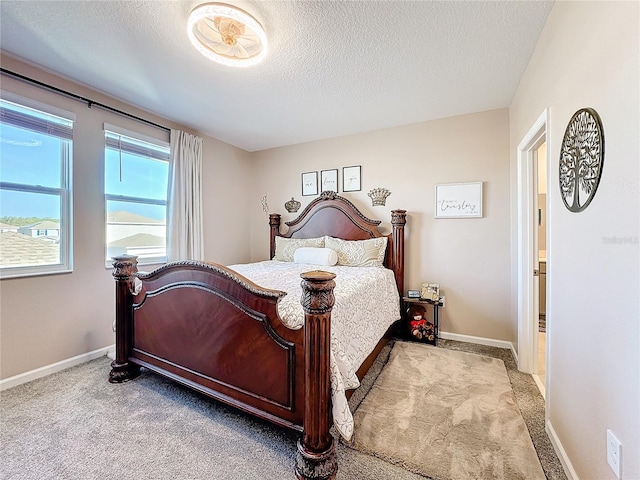 carpeted bedroom featuring a textured ceiling and baseboards