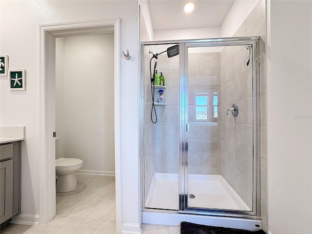 full bath featuring a stall shower, baseboards, toilet, tile patterned flooring, and vanity