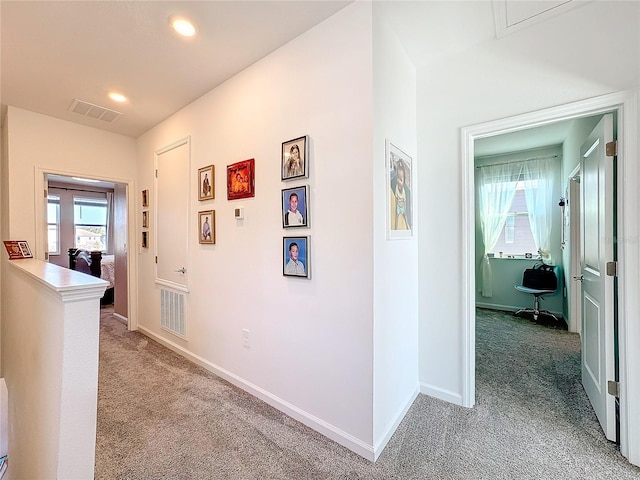 hall with a wealth of natural light, carpet, and visible vents