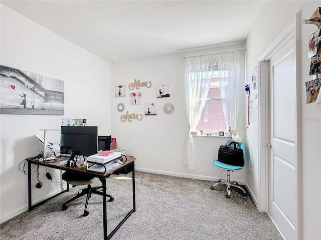 carpeted office featuring a textured ceiling and baseboards