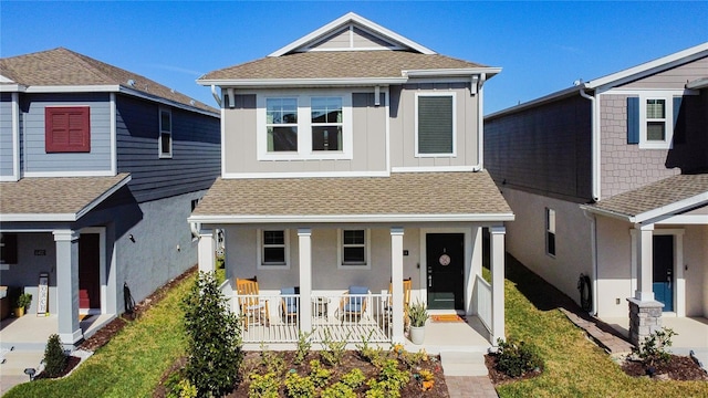 view of front of home featuring covered porch, a shingled roof, board and batten siding, and a front yard