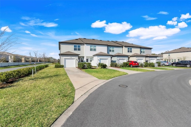 townhome / multi-family property with driveway, a residential view, and a front lawn