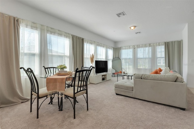 carpeted dining space featuring visible vents