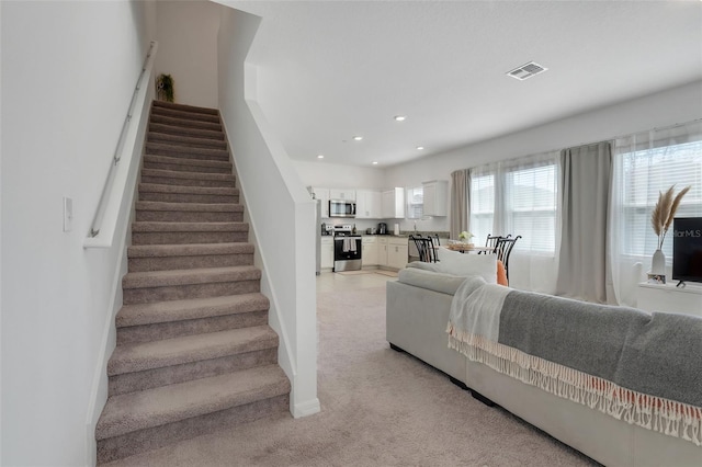 stairs with recessed lighting, visible vents, and baseboards