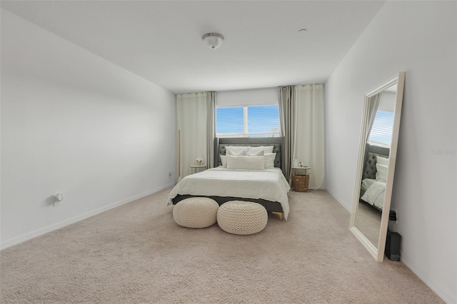 bedroom featuring light carpet and baseboards