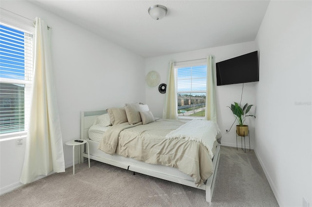 carpeted bedroom with multiple windows and baseboards