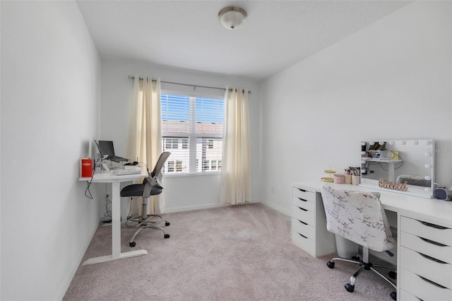 office area featuring light carpet and baseboards