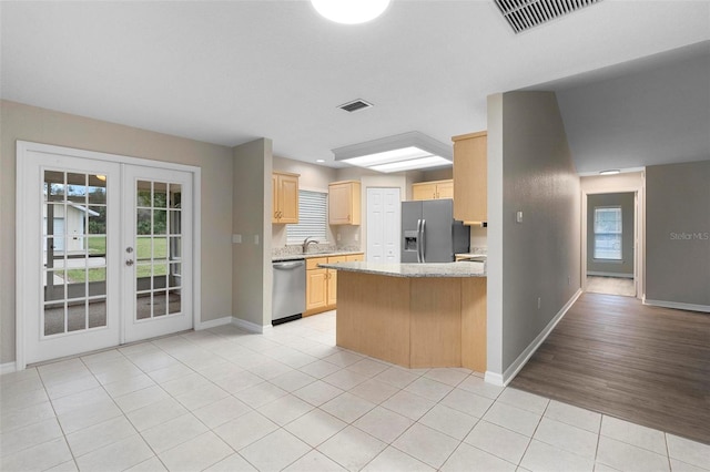 kitchen featuring french doors, light tile patterned floors, stainless steel appliances, visible vents, and light brown cabinets