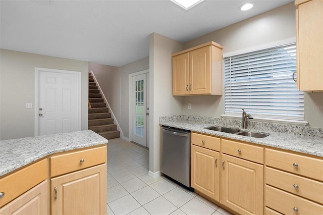 kitchen featuring light tile patterned floors, dishwasher, light stone countertops, light brown cabinets, and a sink