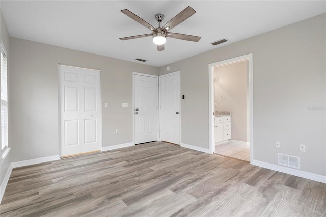 unfurnished bedroom featuring baseboards, visible vents, and light wood finished floors