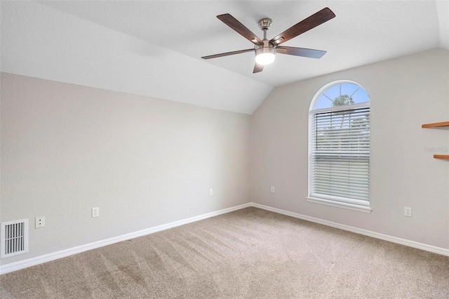 additional living space with carpet floors, lofted ceiling, visible vents, and baseboards