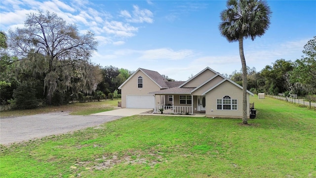 traditional-style home with a garage, concrete driveway, a porch, fence, and a front lawn