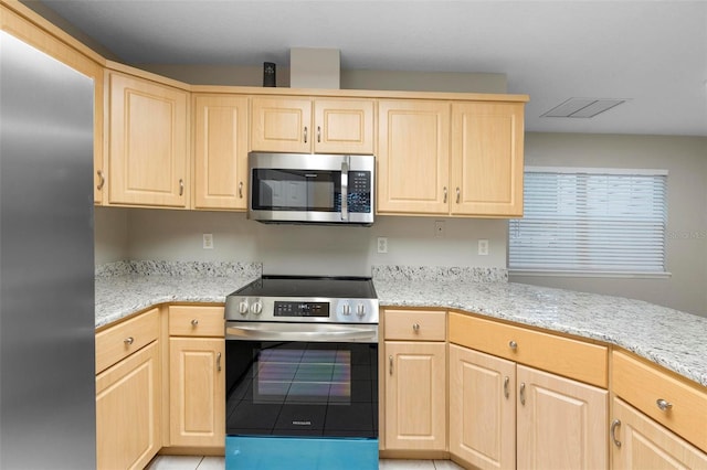 kitchen with stainless steel appliances, light brown cabinets, visible vents, and light stone countertops