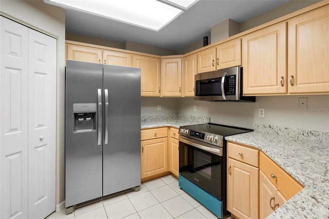 kitchen featuring light tile patterned floors, appliances with stainless steel finishes, light brown cabinets, and light stone counters