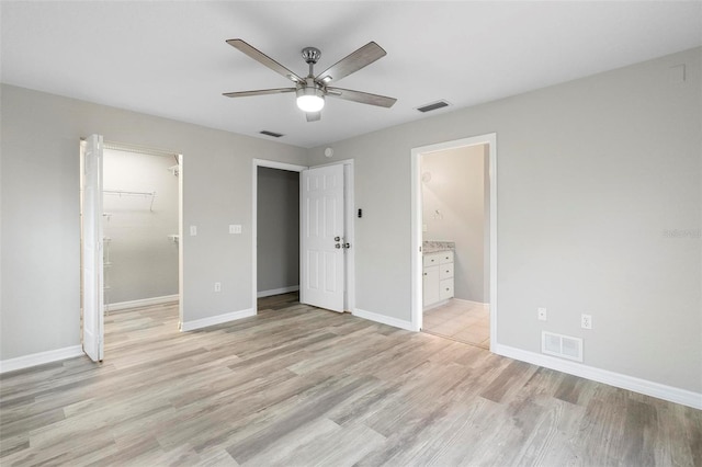 unfurnished bedroom with light wood-type flooring, baseboards, and visible vents