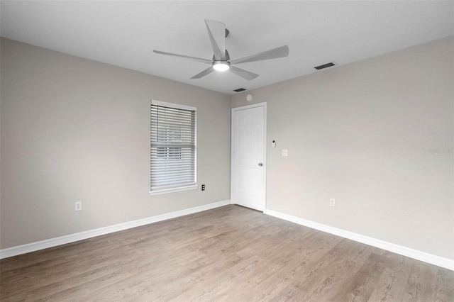 unfurnished room with visible vents, ceiling fan, baseboards, and wood finished floors