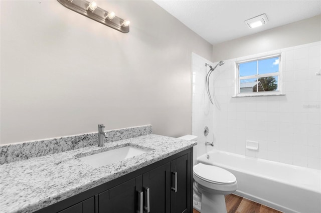 full bathroom with tub / shower combination, vanity, toilet, and wood finished floors