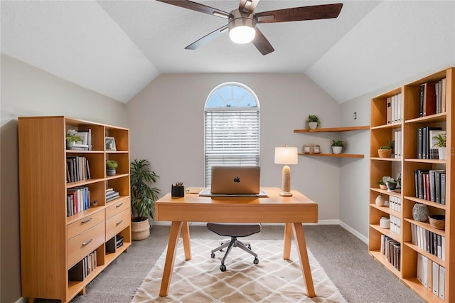 office space with light carpet, lofted ceiling, a ceiling fan, and baseboards