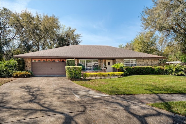 ranch-style home with brick siding, a shingled roof, a garage, driveway, and a front lawn