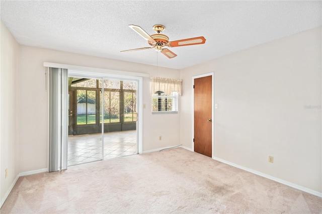 unfurnished room featuring carpet floors, ceiling fan, a textured ceiling, and baseboards