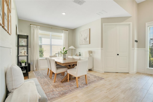 dining space with visible vents, light wood-type flooring, and baseboards