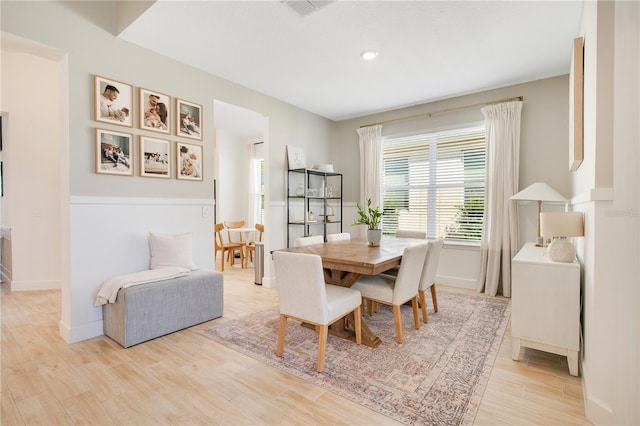 dining space with visible vents, light wood-style flooring, and baseboards