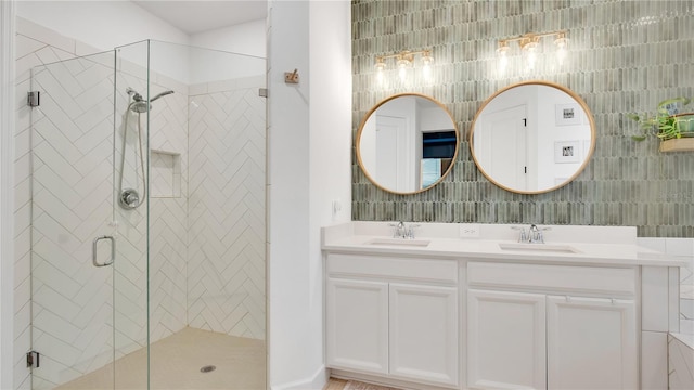 full bathroom featuring a sink, double vanity, and a shower stall