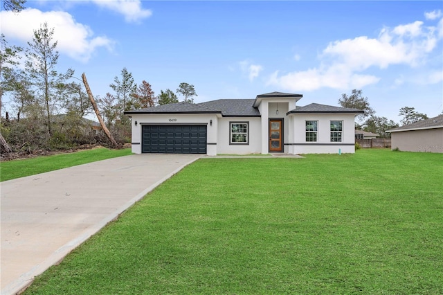 prairie-style house with a garage, concrete driveway, a front lawn, and stucco siding