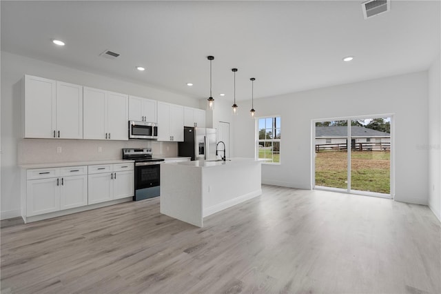 kitchen featuring visible vents, white cabinets, backsplash, stainless steel appliances, and a sink