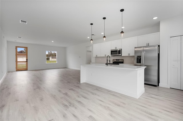 kitchen with appliances with stainless steel finishes, light wood-style floors, visible vents, and white cabinets