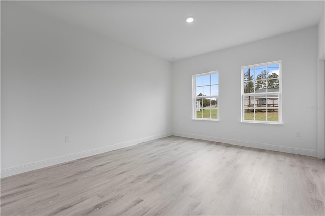 unfurnished room with light wood-style floors, baseboards, and recessed lighting