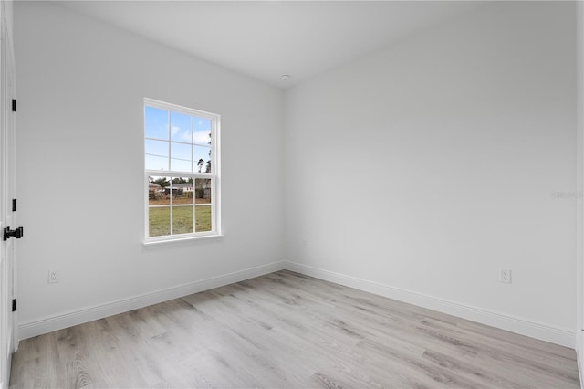 spare room featuring light wood-type flooring and baseboards