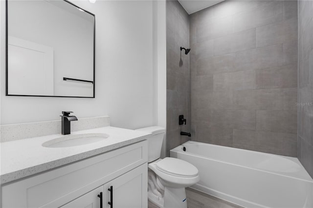 bathroom featuring toilet, wood finished floors, shower / tub combination, and vanity