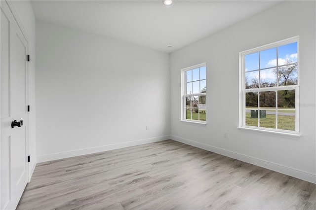 spare room featuring recessed lighting, light wood-style flooring, and baseboards