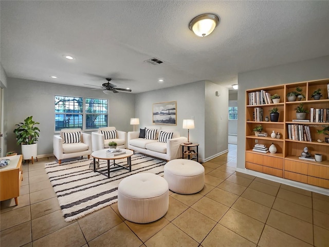 living room with recessed lighting, visible vents, a textured ceiling, and light tile patterned floors