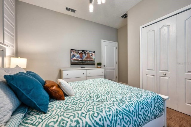 bedroom featuring a closet, visible vents, and light carpet