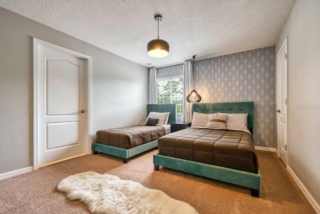 bedroom with carpet, baseboards, and a textured ceiling