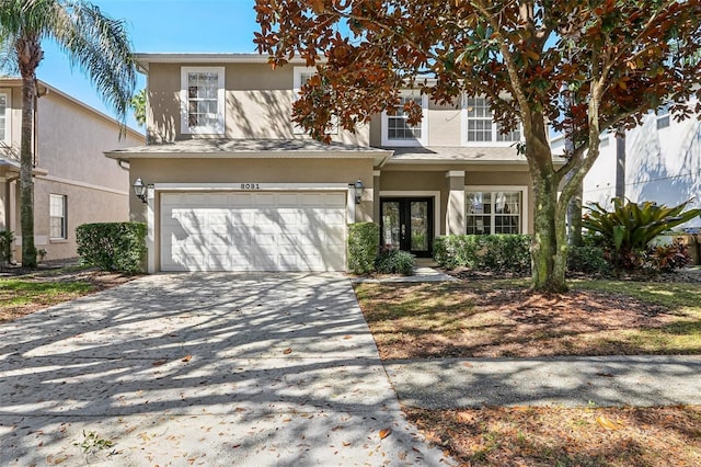 view of front of home featuring driveway, french doors, and stucco siding