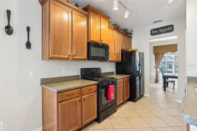 kitchen with light tile patterned floors, visible vents, brown cabinets, rail lighting, and black appliances