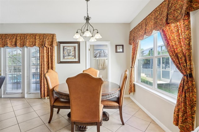 dining room featuring light tile patterned floors, baseboards, and an inviting chandelier