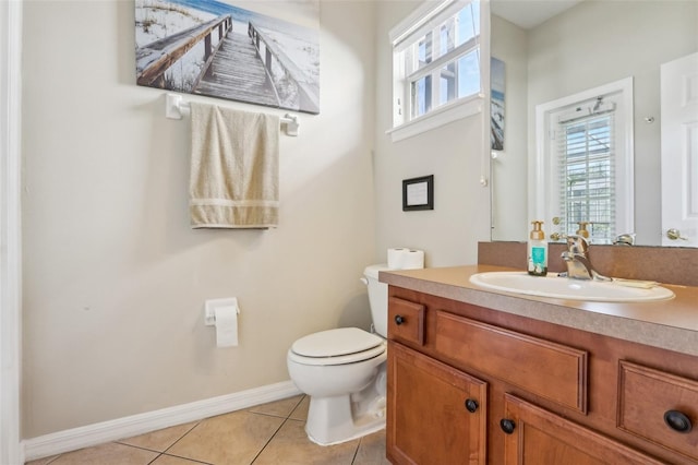 half bathroom with tile patterned flooring, baseboards, vanity, and toilet