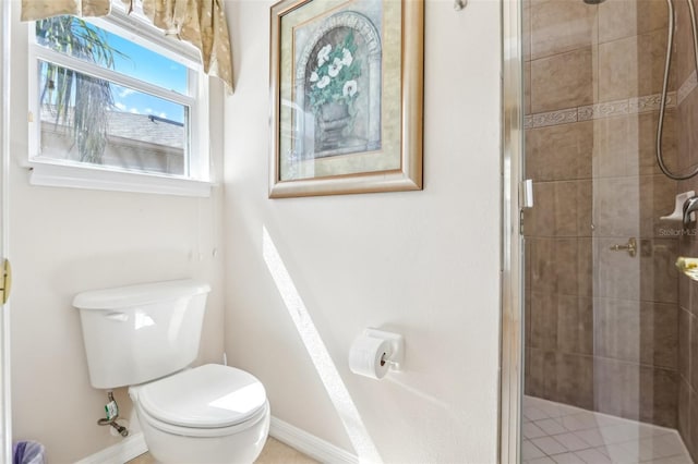 full bathroom with toilet, a stall shower, and baseboards