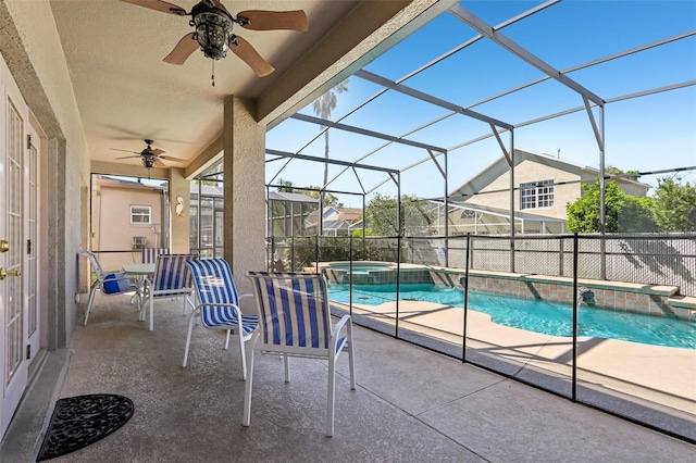 view of swimming pool featuring ceiling fan, a lanai, fence, a pool with connected hot tub, and a patio area